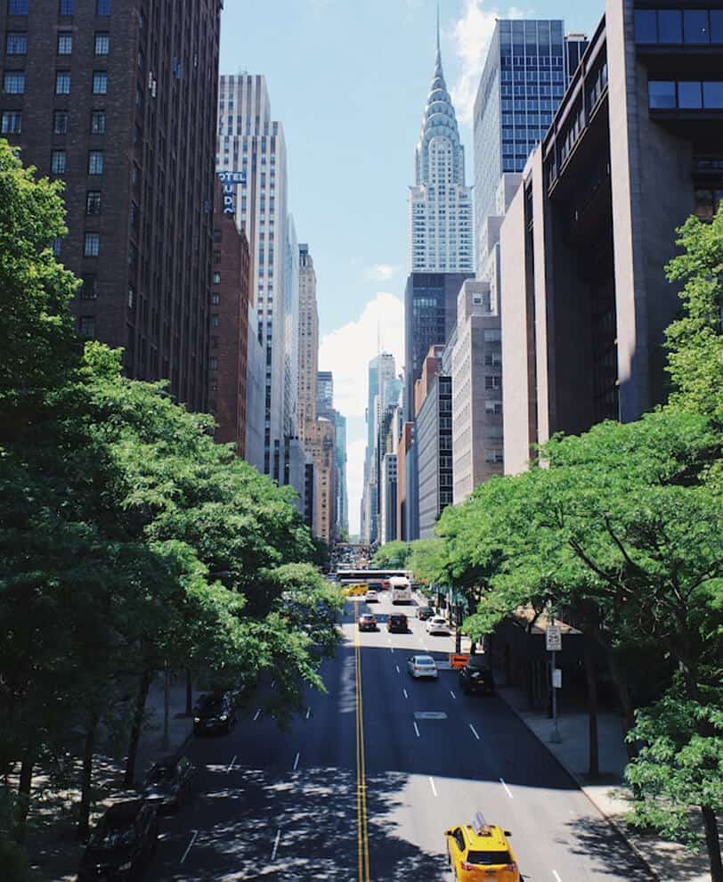 Tree-lined Manhattan street with the Chrysler Building in the background